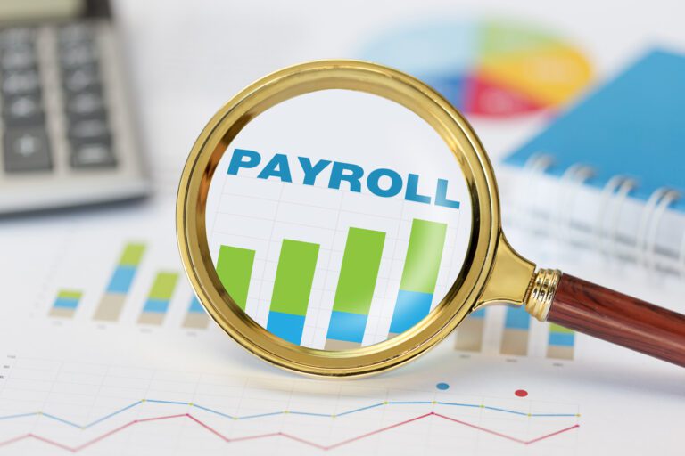 Magnifying glass and calculator on payroll graph