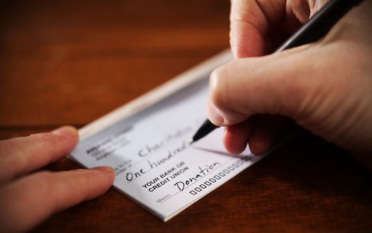 Writing a donation check to a charitable organization